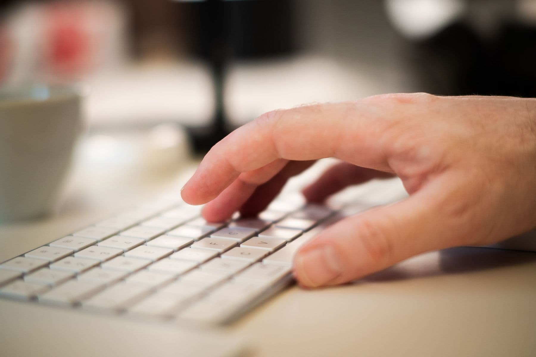 A close-up of a hand typing on a keyboard.